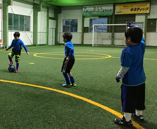 コートでボールを蹴る子どもたち